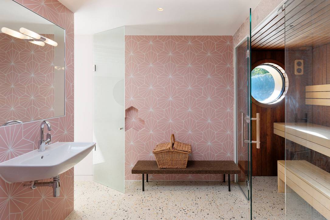Spa changing room featuring terrazzo tiled walls, wooden bench, and walk-in shower, Love Locations OX7.