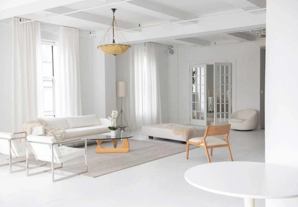 Open-plan studio layout in NYC, NY 10011 showcasing white-painted columns, large windows, and contemporary lounge arrangements for commercial film crews, Love Locations.