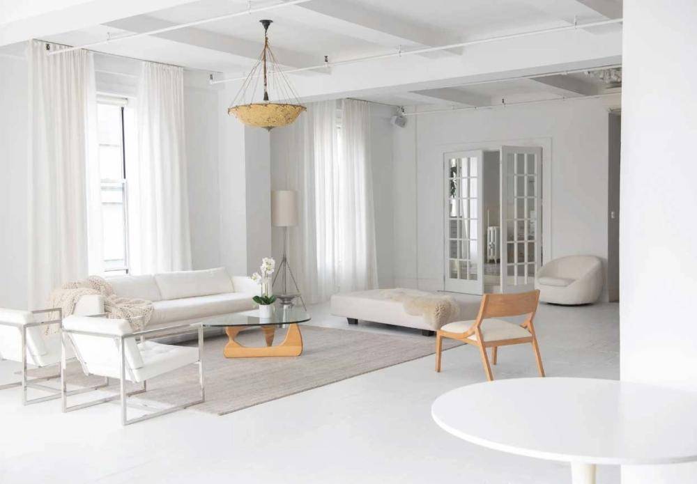 Open-plan studio layout in NYC, NY 10011 showcasing white-painted columns, large windows, and contemporary lounge arrangements for commercial film crews, Love Locations.