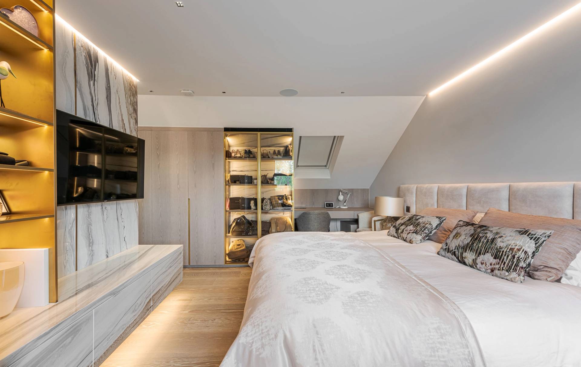 Loft bedroom suite set under sloped roof ceilings with LED strip lighting and neutral decor, Love Locations SW11.