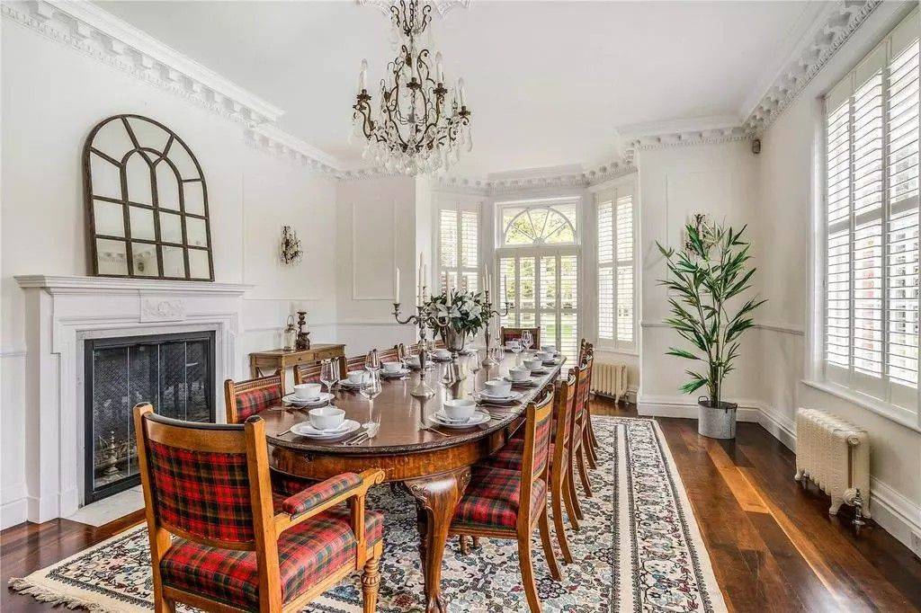 Formal period dining room photo location featuring a long mahogany dining table, red tartan dining chairs, ornate ceiling coving, and a crystal chandelier through Love Locations.