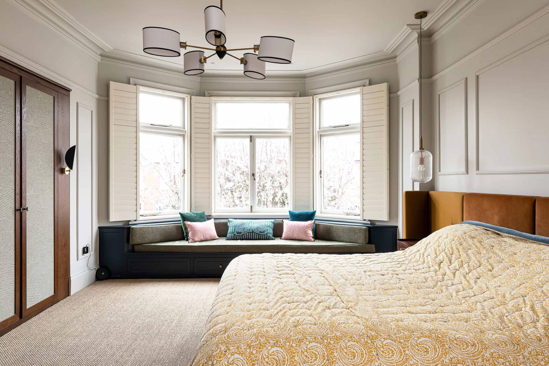 Master bedroom bay window detail with a built-in window seat bench and neutral linen bedding, Love Locations NW6.