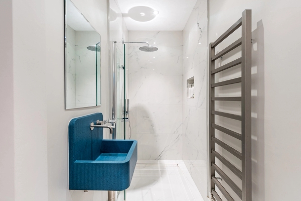 Designer walk-in shower room featuring a unique cobalt blue basin and marble wall tiling, Love Locations Essex.