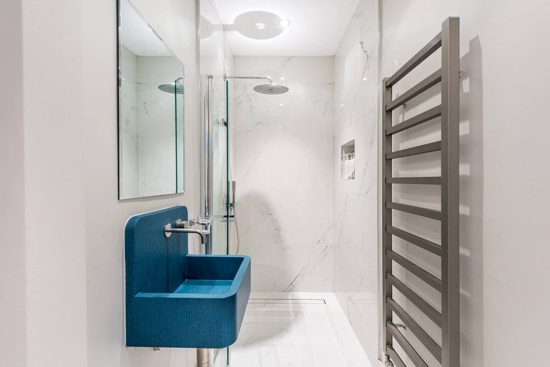 Designer walk-in shower room featuring a unique cobalt blue basin and marble wall tiling, Love Locations Essex.