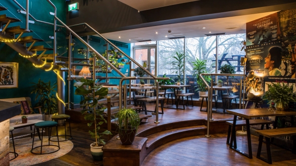 Sunlit cafe-bar seating area near expansive glass windows at The Ritzy, Brixton, SW2, suitable for casual lifestyle brand campaigns and commercial filming, Love Locations.
