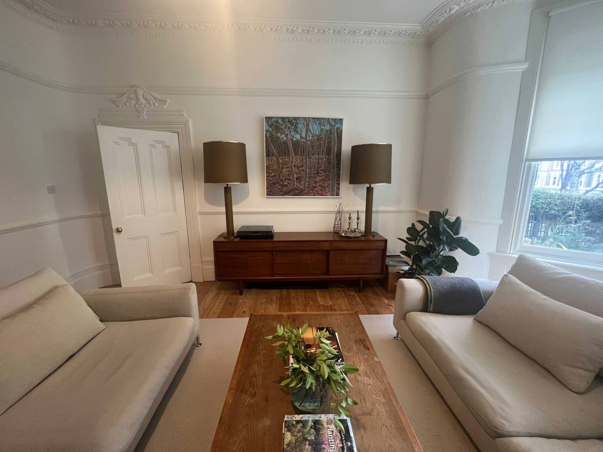 Symmetrical shot of twin table lamps on a wooden credenza flanked by neutral sofas in Denmark Hill, Love Locations SE5.