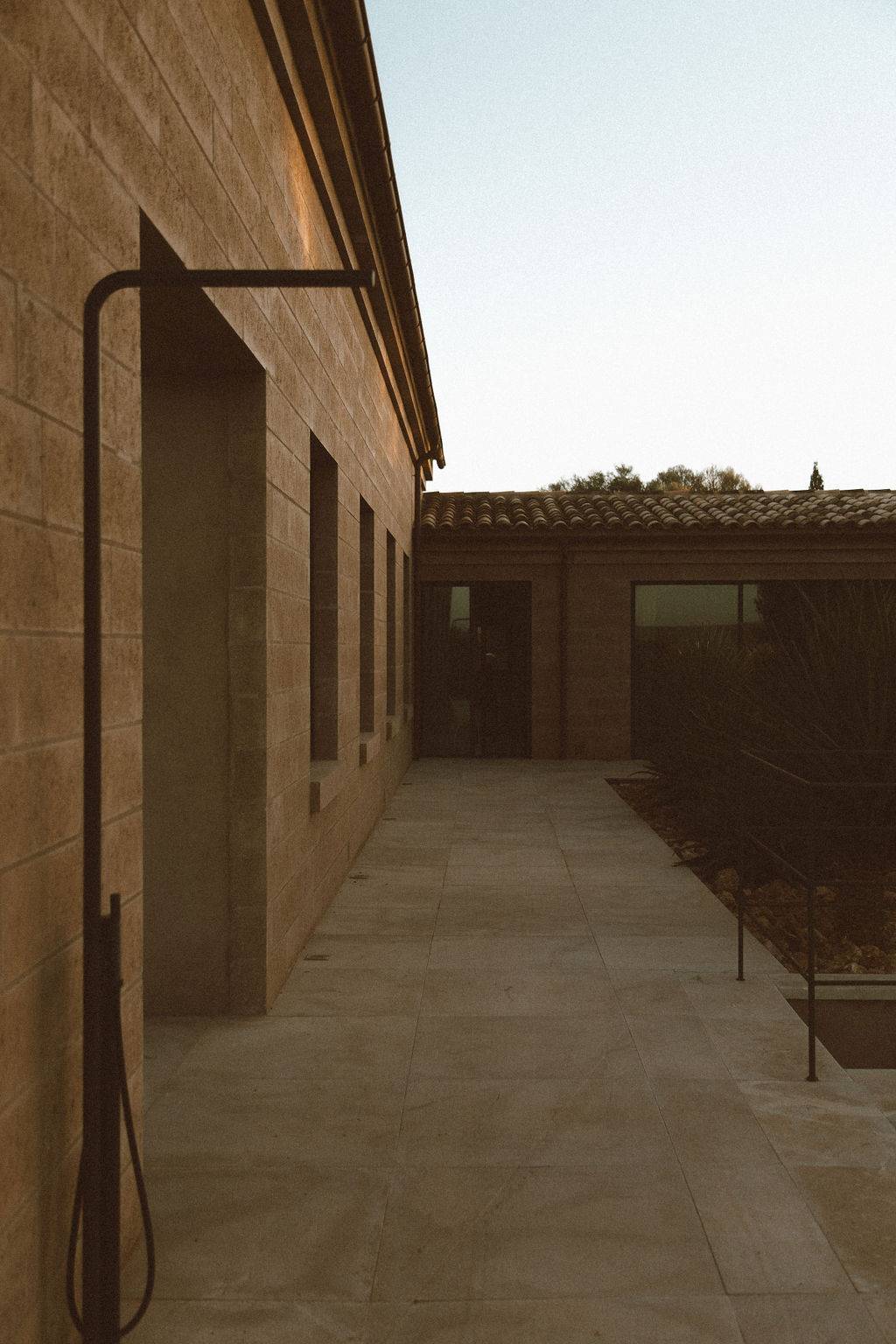 Stone pathway running along the exterior facade of a luxury modern villa, Love Locations 07630.