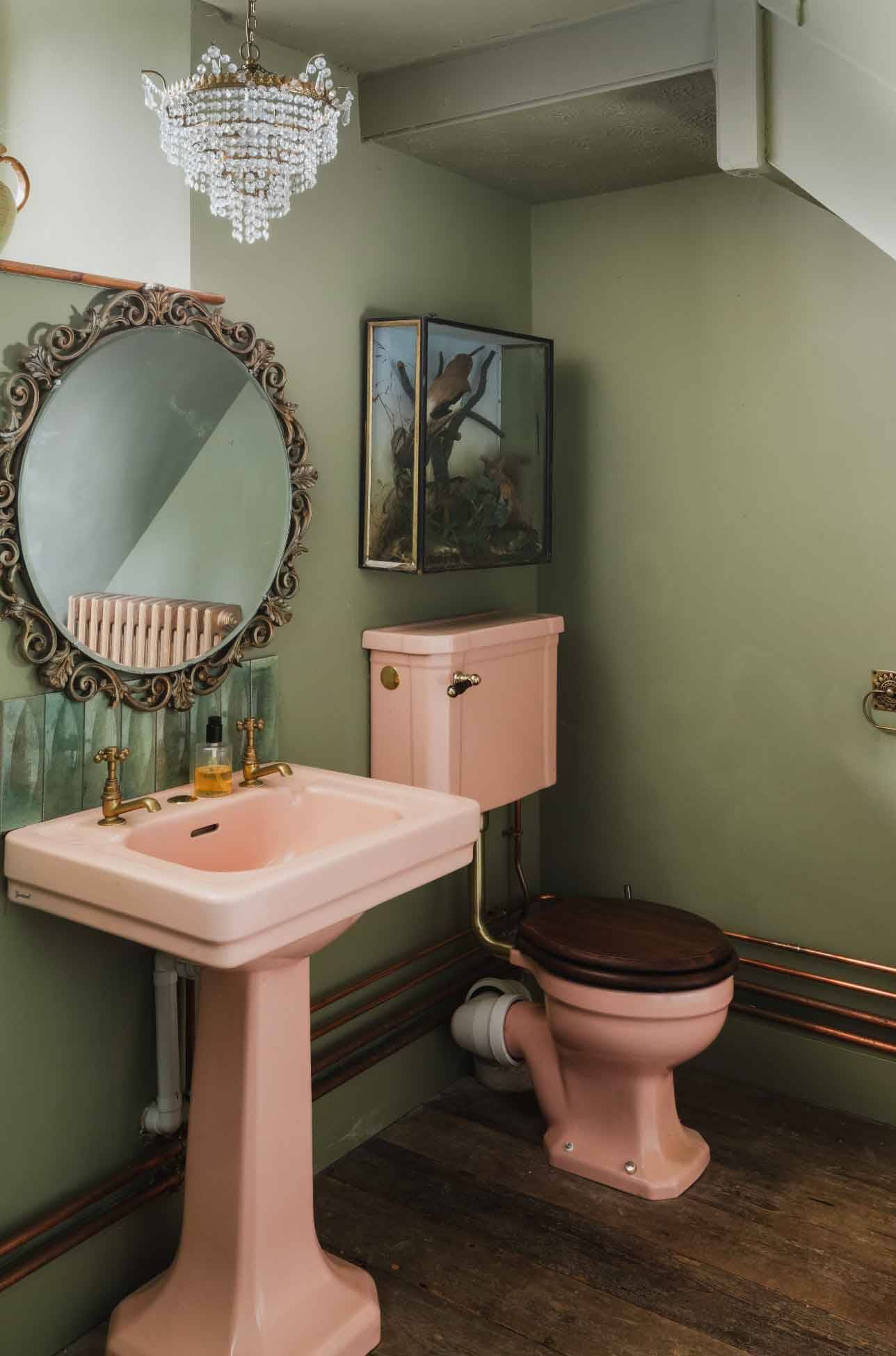 Vintage pink pedestal sink and toilet in a green-painted period bathroom shoot space via Love Locations.