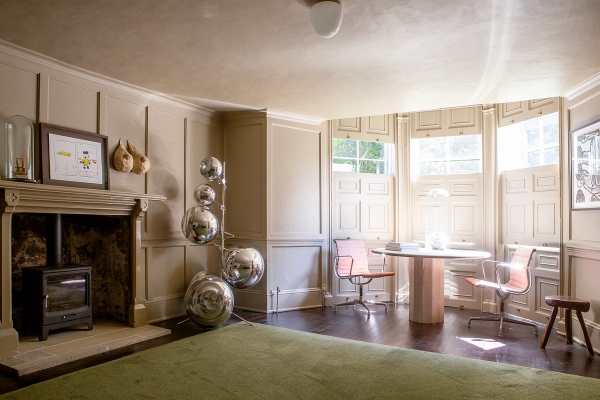 Lounge room view showing a open fireplace hearth, disco ball sculptures, and bay window seating, Love Locations ME13.