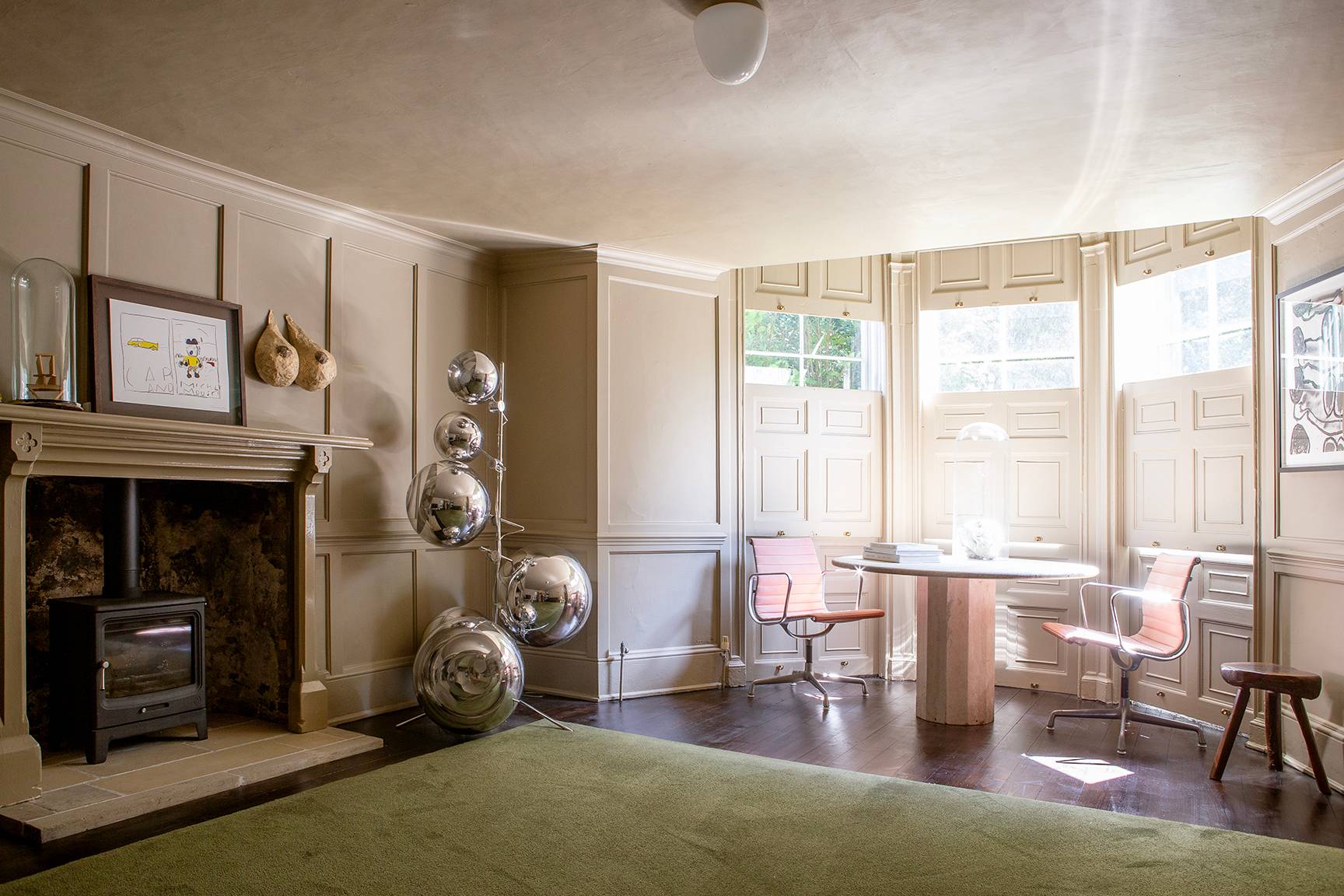Lounge room view showing a open fireplace hearth, disco ball sculptures, and bay window seating, Love Locations ME13.