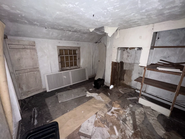 Run-down empty room with crumbling lath and plaster walls and debris-strewn floorboards, available for film production hire via Love Locations.