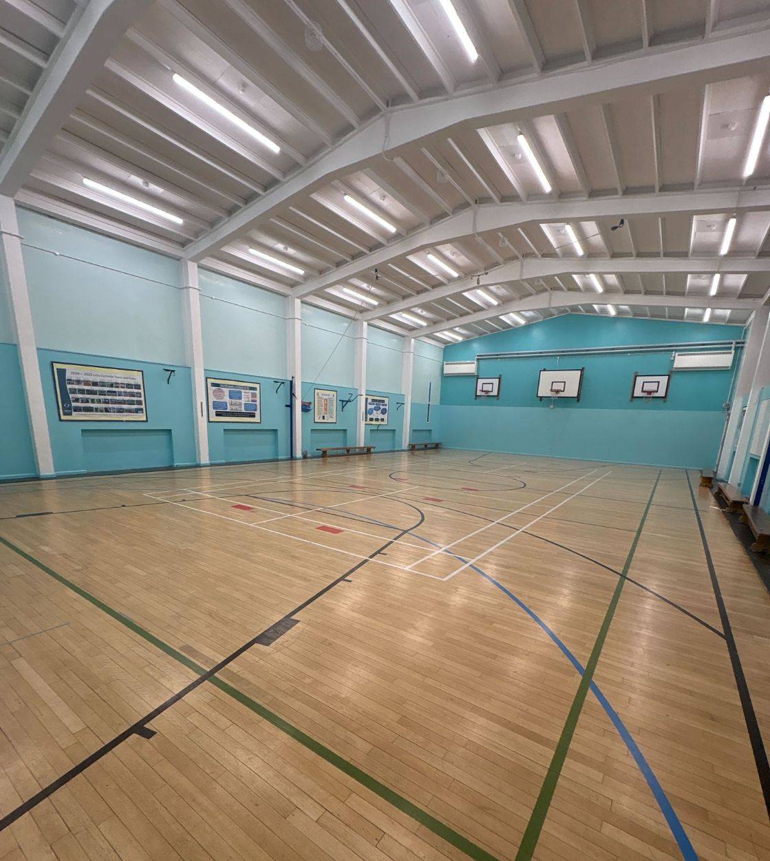 Bright indoor sports hall photo location featuring high ceilings and light blue wall finishes by Love Locations.
