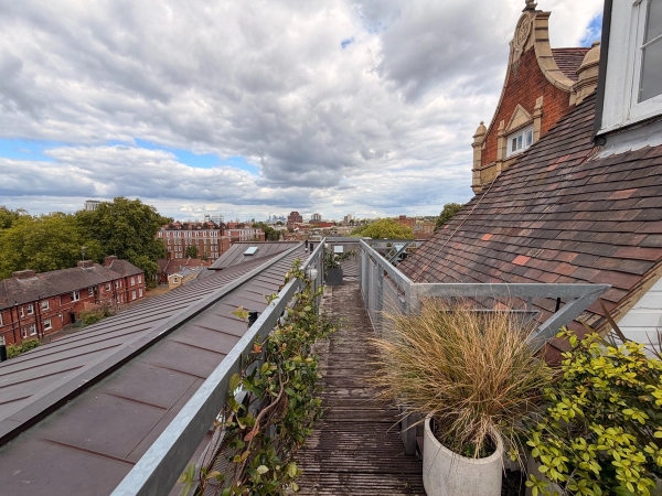 Elevated rooftop decking walkway and outdoor terrace space for brand shoots in Brixton SW4 through Love Locations, with potted plants and brick chimney details.
