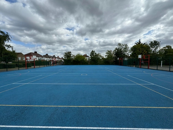 Love Locations blue tarmac sports court Cockfosters EN4: Multi-use hardstanding games area surfaced in vibrant blue paint with multi-sport white lines, perfect for outdoor fitness photography.