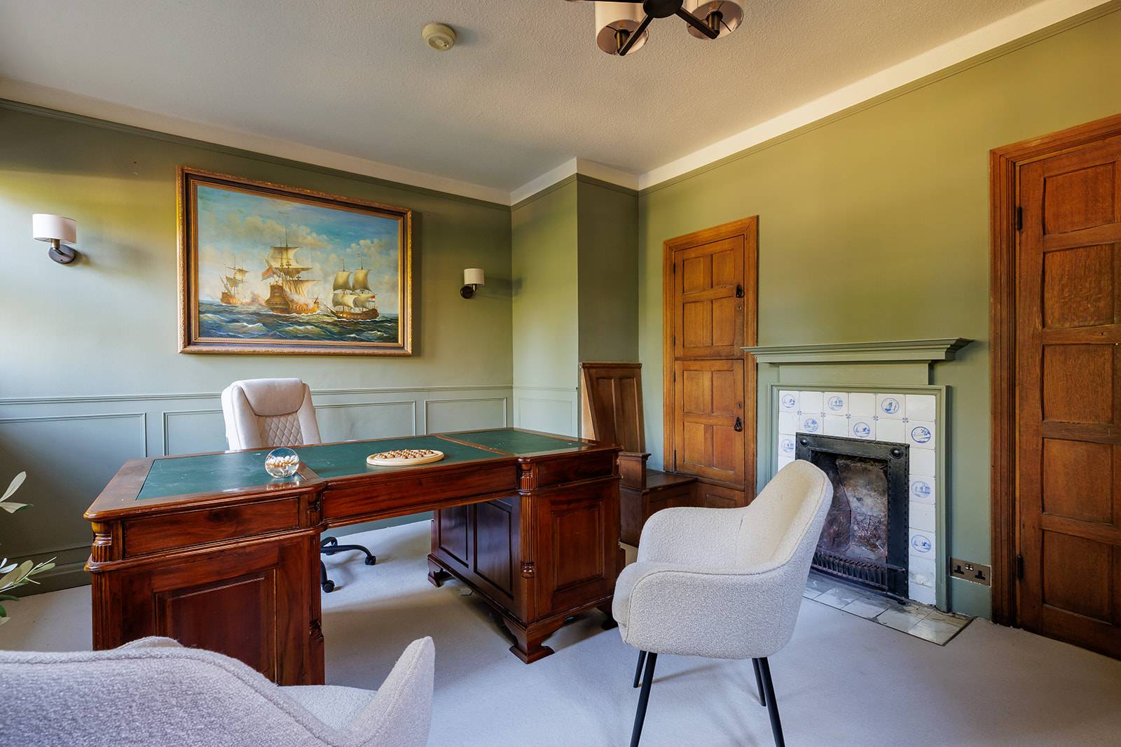Traditional study room featuring an executive wooden desk, marble fireplace hearth, and green panelled walls, Love Locations RH13.