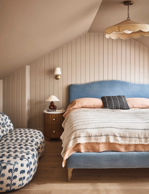 Cozy attic bedroom with vertical wood panelling, blue upholstered bed frame, and soft striped bedding, Love Locations SE21.