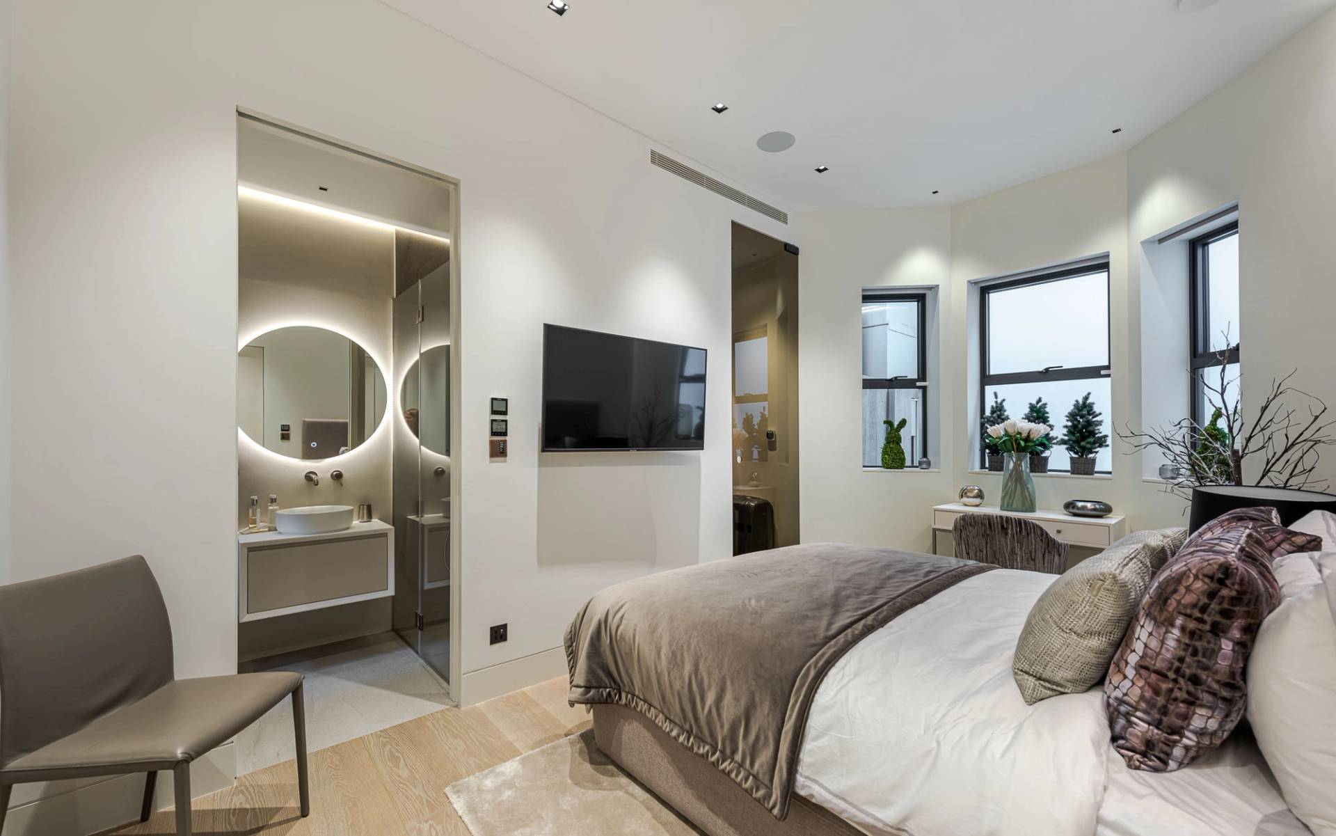 Guest bedroom suite with open ensuite glass shower wall and plush neutral textiles, Love Locations SW11.