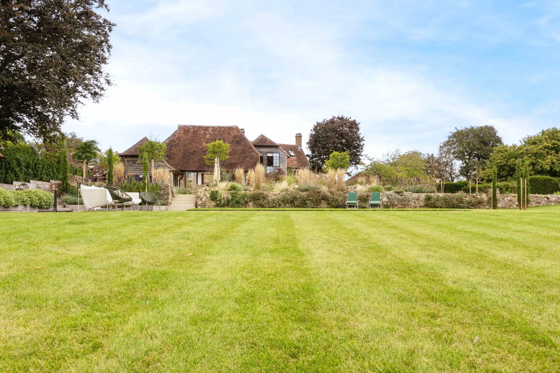 Expansive manicured lawn garden with mature trees and stone boundary walls in Petworth, Love Locations GU28.
