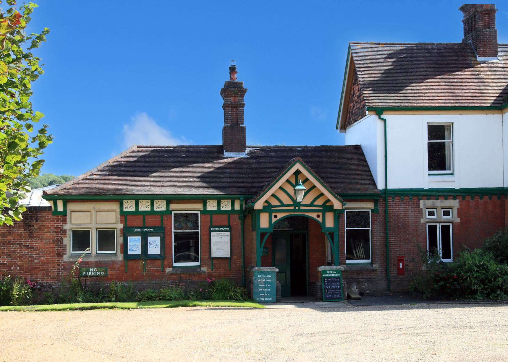 Heritage railway station shoot location hero cover image in Sheffield Park, Uckfield, Sussex, TN22 3QL featuring a Victorian red brick ticket office facade, green timber gables, and gravel entrance, the ultimate high-visibility backdrop for period film drama, TV commercials, and luxury brand campaigns via Love Locations.
