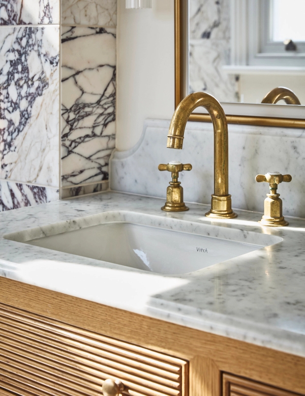 Under-mount marble bathroom sink detail featuring warm brass taps and marble backsplash, Love Locations SE21.