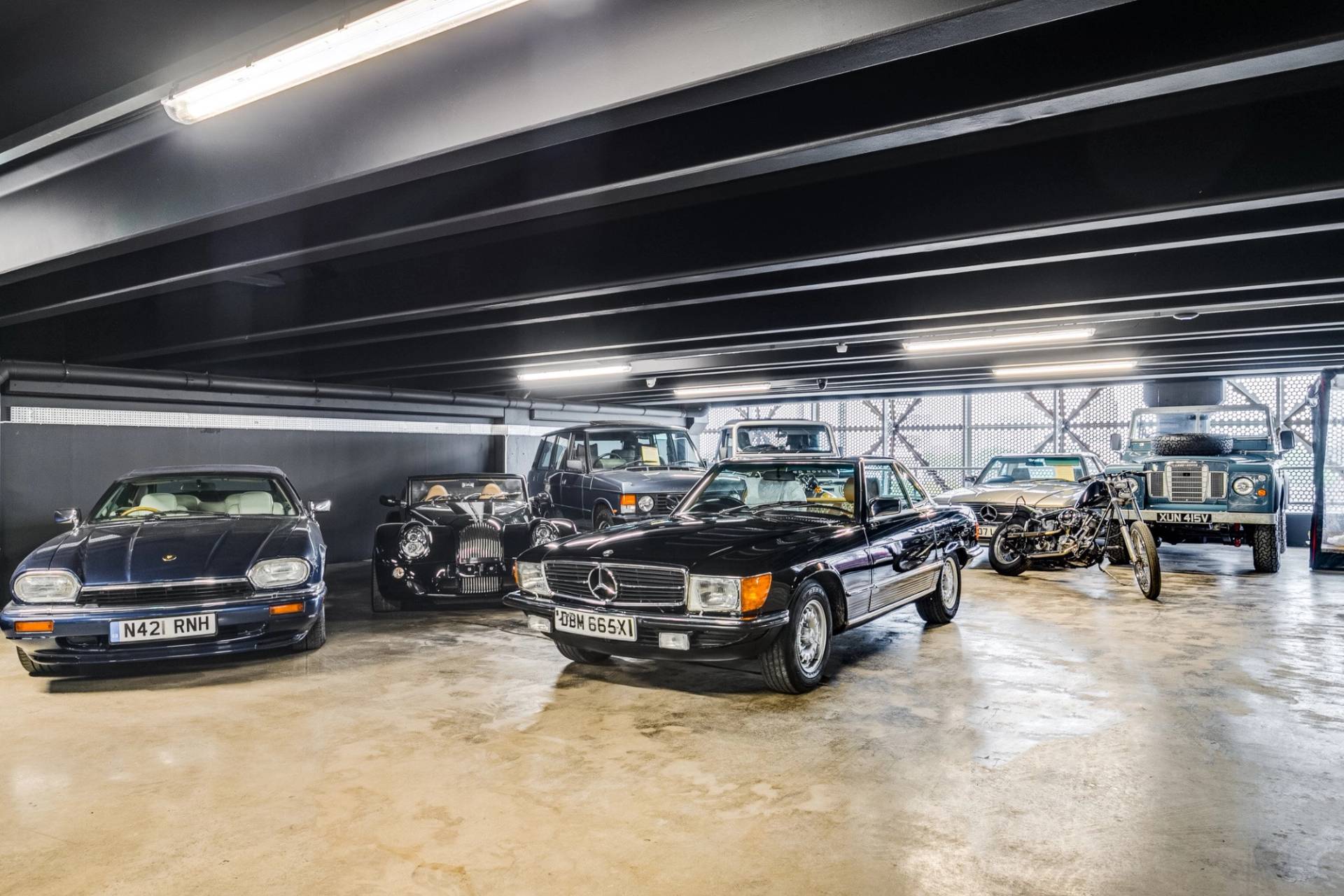 Classic Mercedes-Benz and luxury cars on display in a 1950s factory showroom in Brentford from Love Locations.