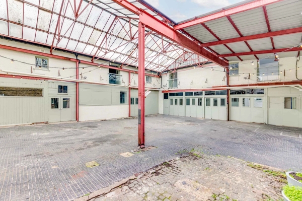 Urban industrial location featuring red steel framework and distressed paving for music videos, booked through Love Locations.