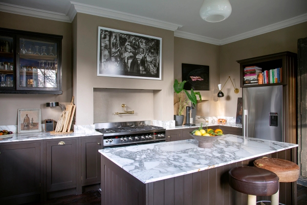 Sleek kitchen island with veined marble countertops, dark wooden cabinetry, and Range oven, Love Locations ME13.