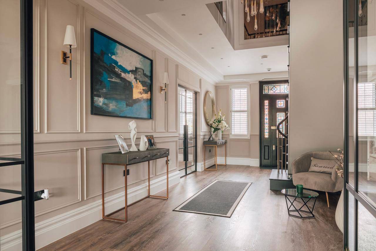 Spacious entrance foyer with black double doors, glass console table, and wall moulding details in Ealing, Love Locations W5.