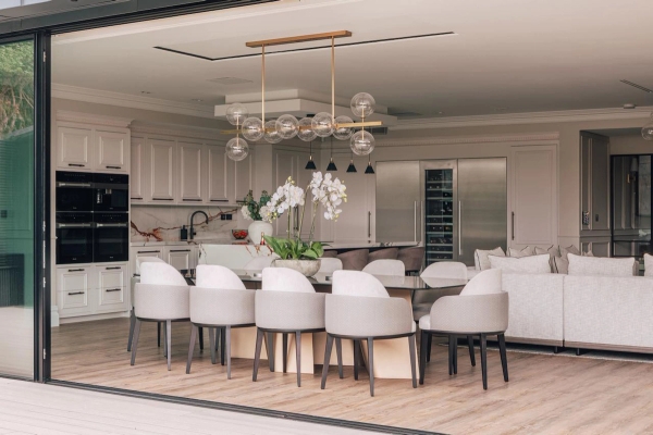 Natural light flooding a modern kitchen through glass sliding doors.