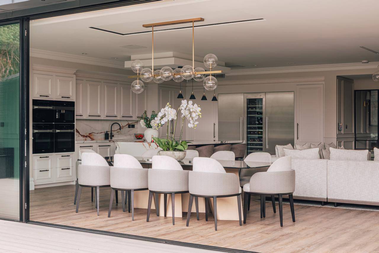 Spacious open-plan kitchen and dining room with a oval marble table, cream chairs, and glass bubble chandelier in Ealing, West London, perfect for culinary TV ads, Love Locations W5.