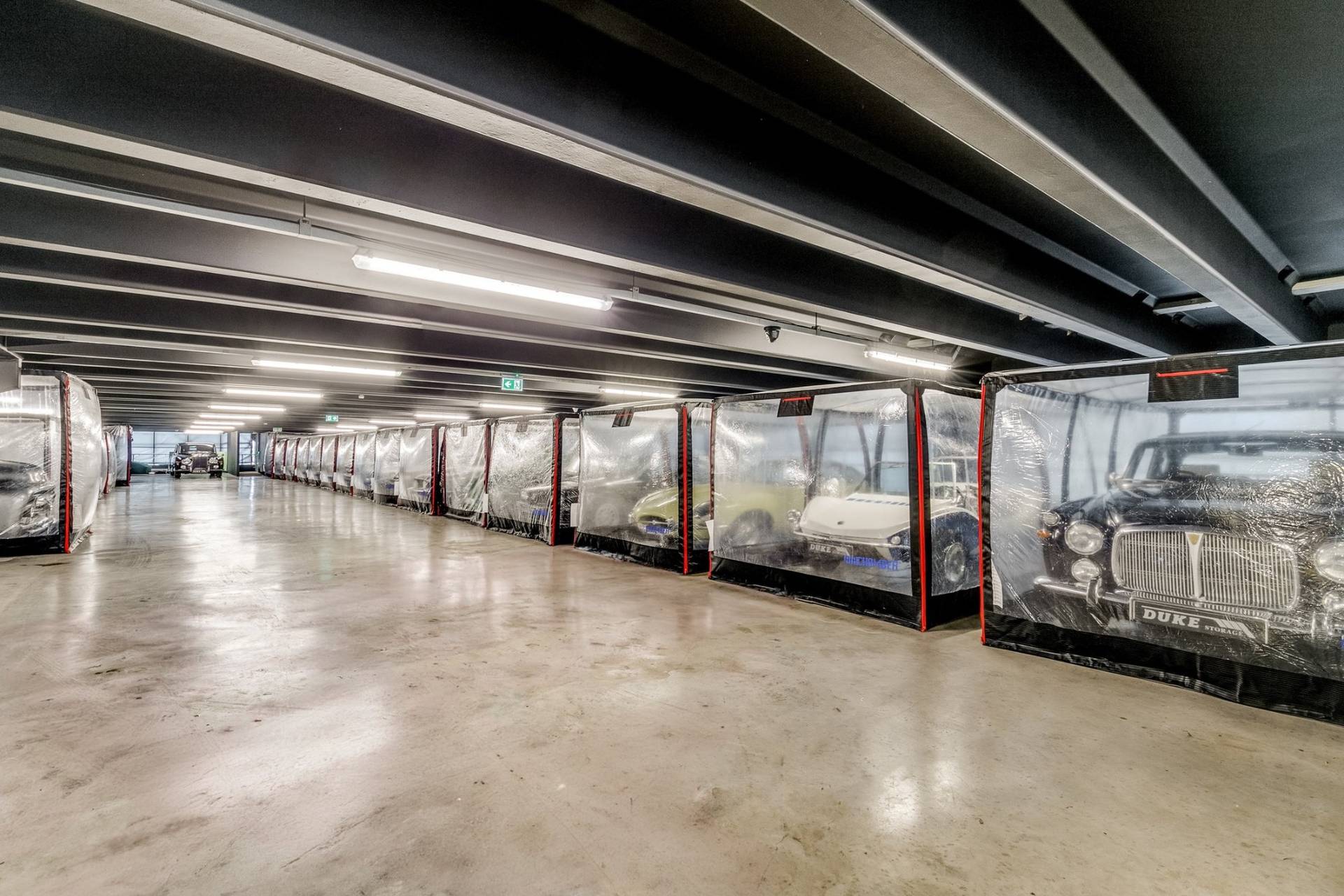 Long corridor of classic vehicles in protective storage pods in a 1950s Brentford factory location from Love Locations.