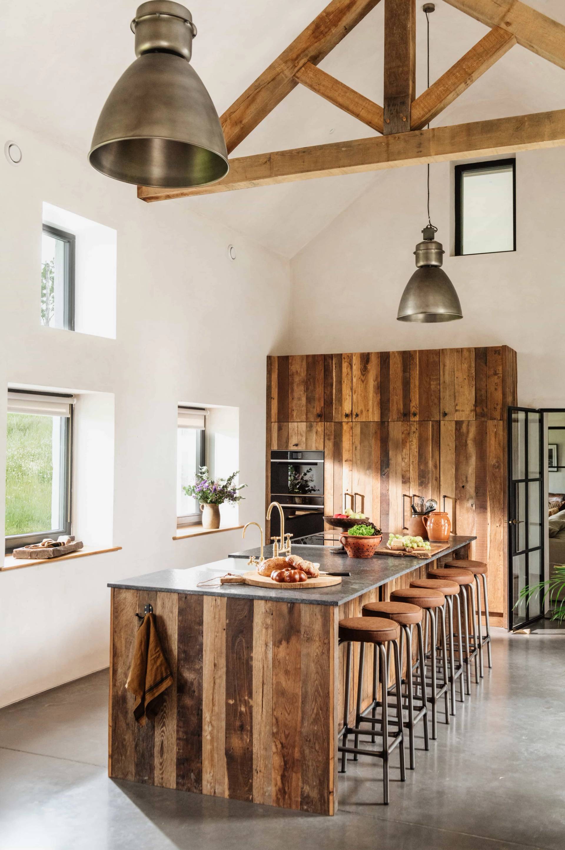 Light-filled farmhouse kitchen and dining area for film hire in Castleblayney County Monaghan Ireland through Love Locations, displaying rustic wooden finishes and tall windows.