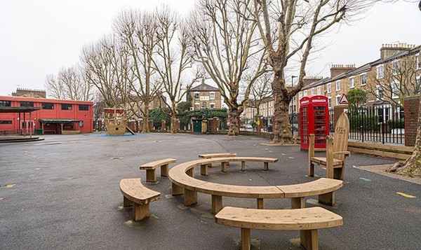 School playground location featuring circular wooden benches under mature trees, perfect for youth brand photography, Love Locations.