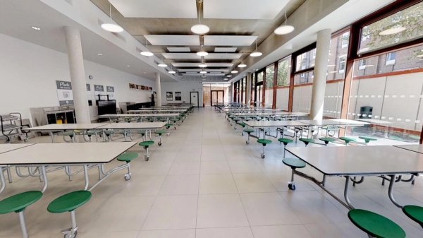 Expansive secondary school canteen and dining hall location with folding tables and green stools, Love Locations SE22.