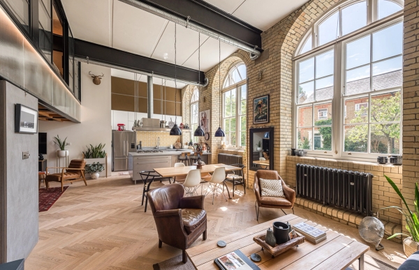 Characterful residential sitting room location with leather armchairs, a large arched window, and exposed brickwork, Love Locations.