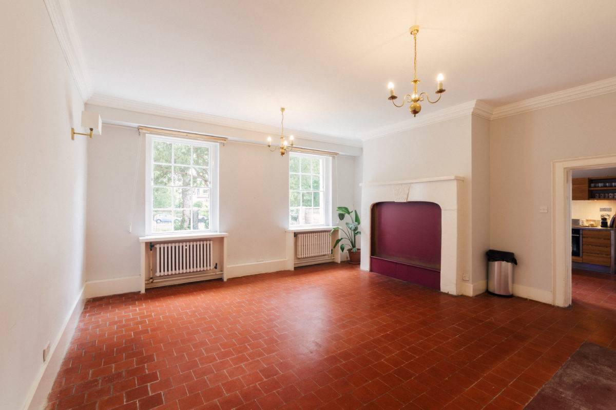 Bright reception space featuring terracotta tile floors, twin sash windows, and a curved hearth, perfect for homeware brand ads, Love Locations.