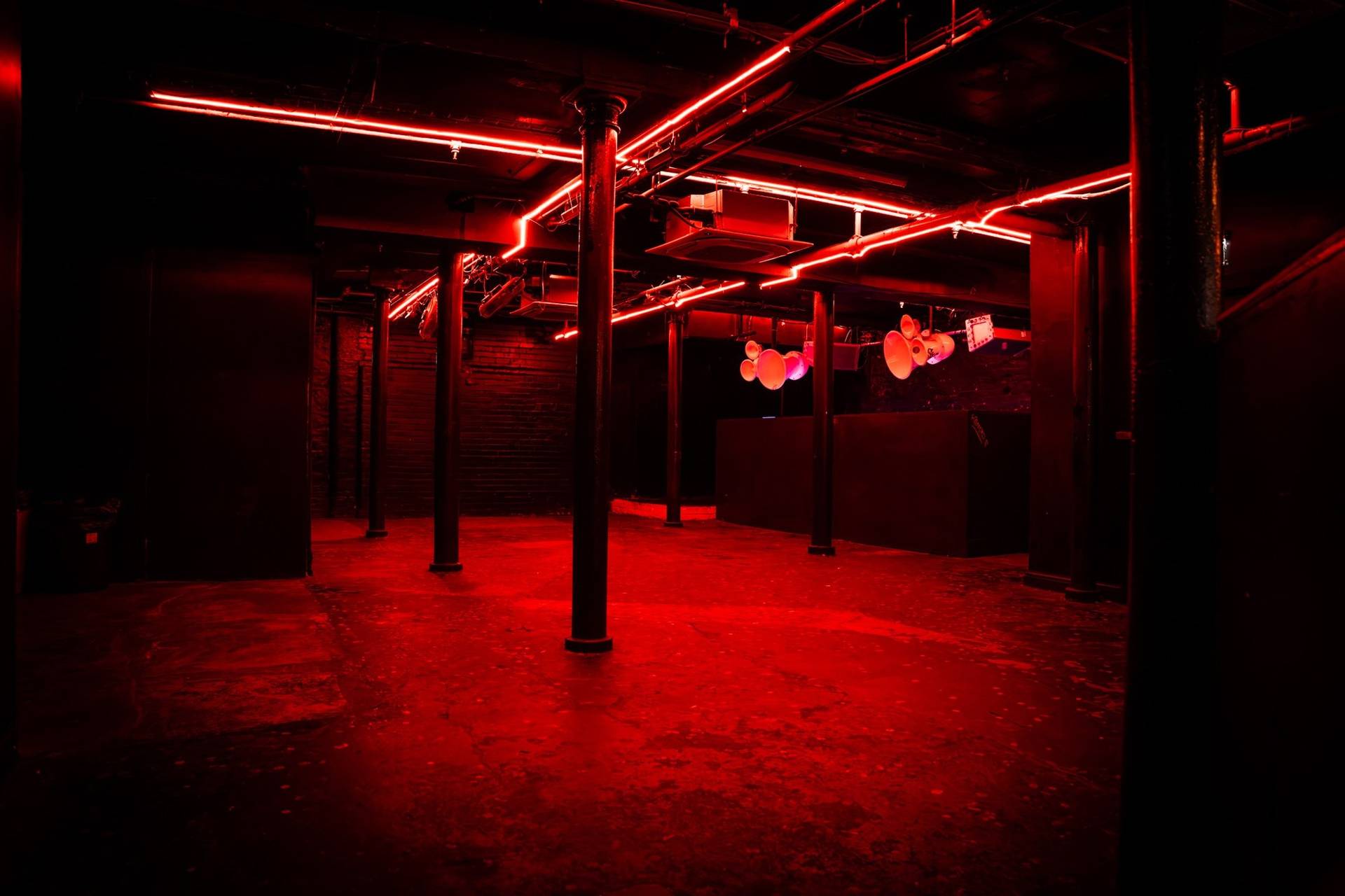 Crimson red ambient illuminated venue floor with exposed support columns in Cheetham Hill Manchester M3 from Love Locations.