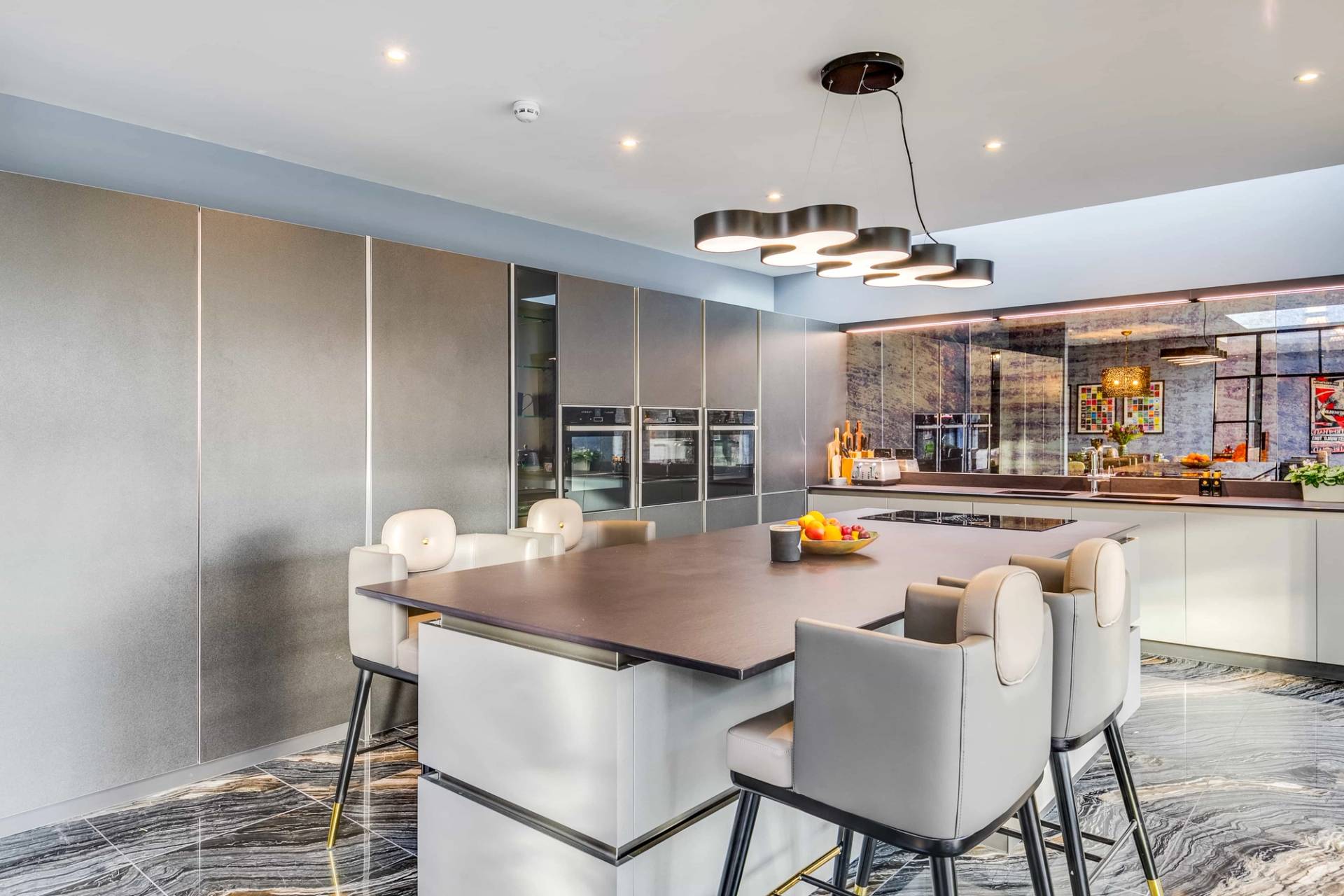 Modern kitchen prep island set under recessed LED ceiling lighting in a luxury Cambridge location home, Love Locations CB2.