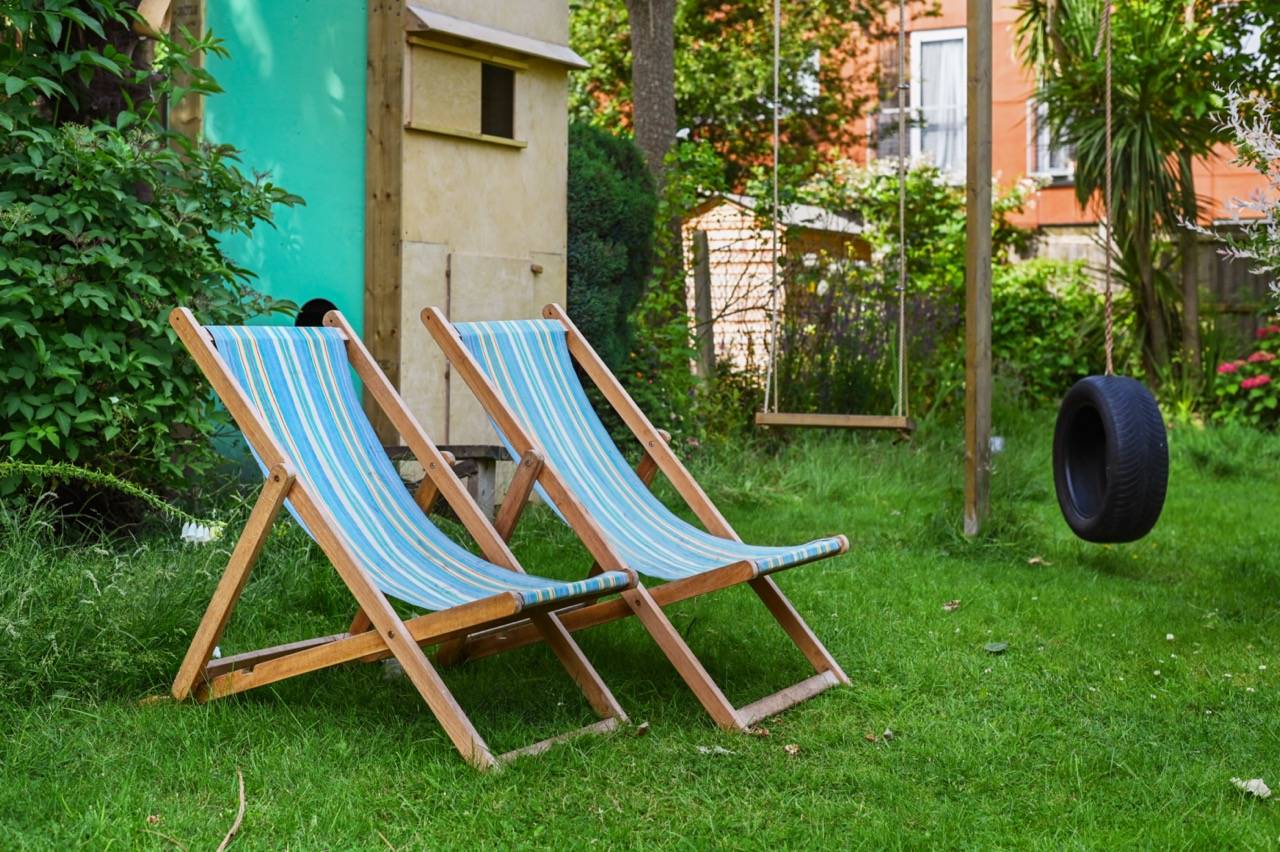 Blue and white striped garden deck chairs relaxing on a green lawn, ideal for summer campaign photography, Love Locations E7.