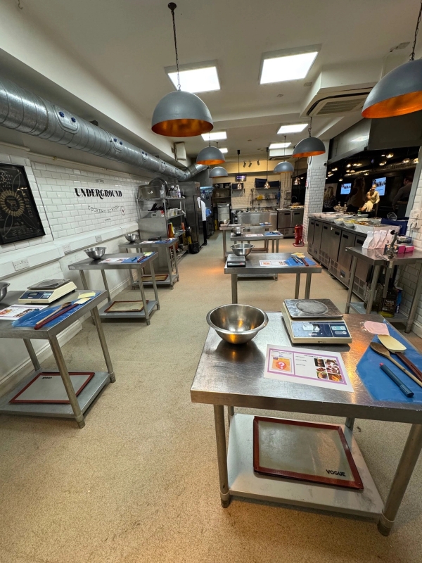 Expansive underground commercial kitchen for hire, showing the full length of the preparation floor in Central London, via Love Locations.