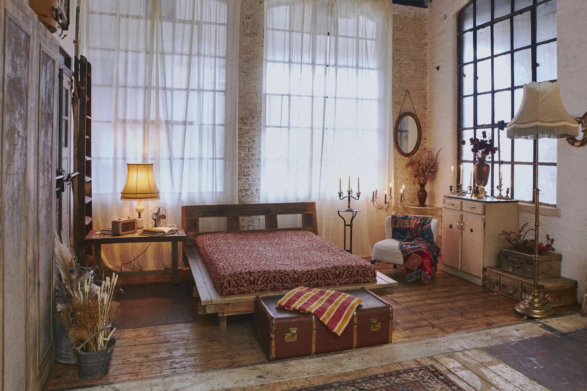 Close-up of a vintage bed arrangement on original wooden floorboards inside a historic industrial warehouse conversion, Love Locations.