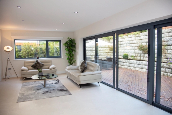 Spacious living room location space opening directly onto an outdoor timber decking terrace via large sliding doors, managed by Love Locations.