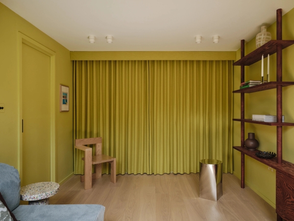 Love Locations bold chartreuse wall room Lewisham SE23: Atmospheric reading room with lime-chartreuse walls, integrated wooden floating shelves, and a sculptural wooden chair, perfect for music videos.