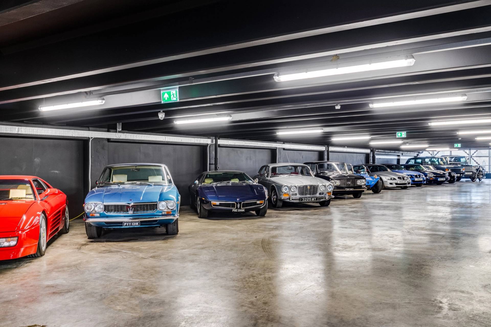 Collection of vintage sports cars parked on polished concrete in a Brentford car showroom by Love Locations.