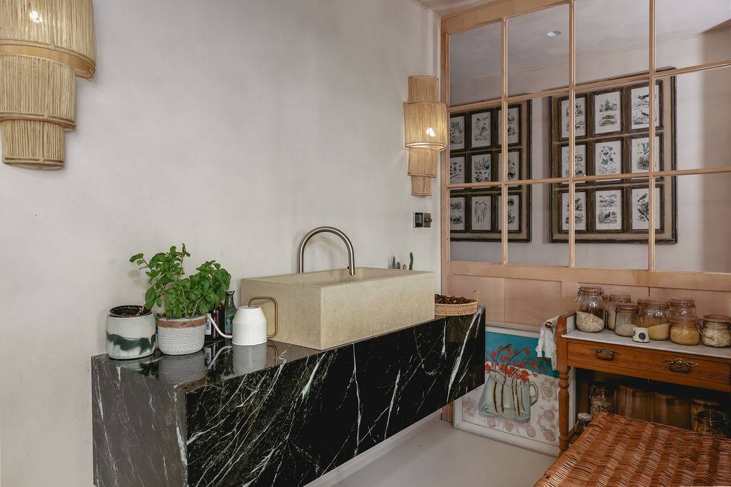 Black marble island counter with sink hardware and neutral microcement wall panelling, Love Locations GU32.