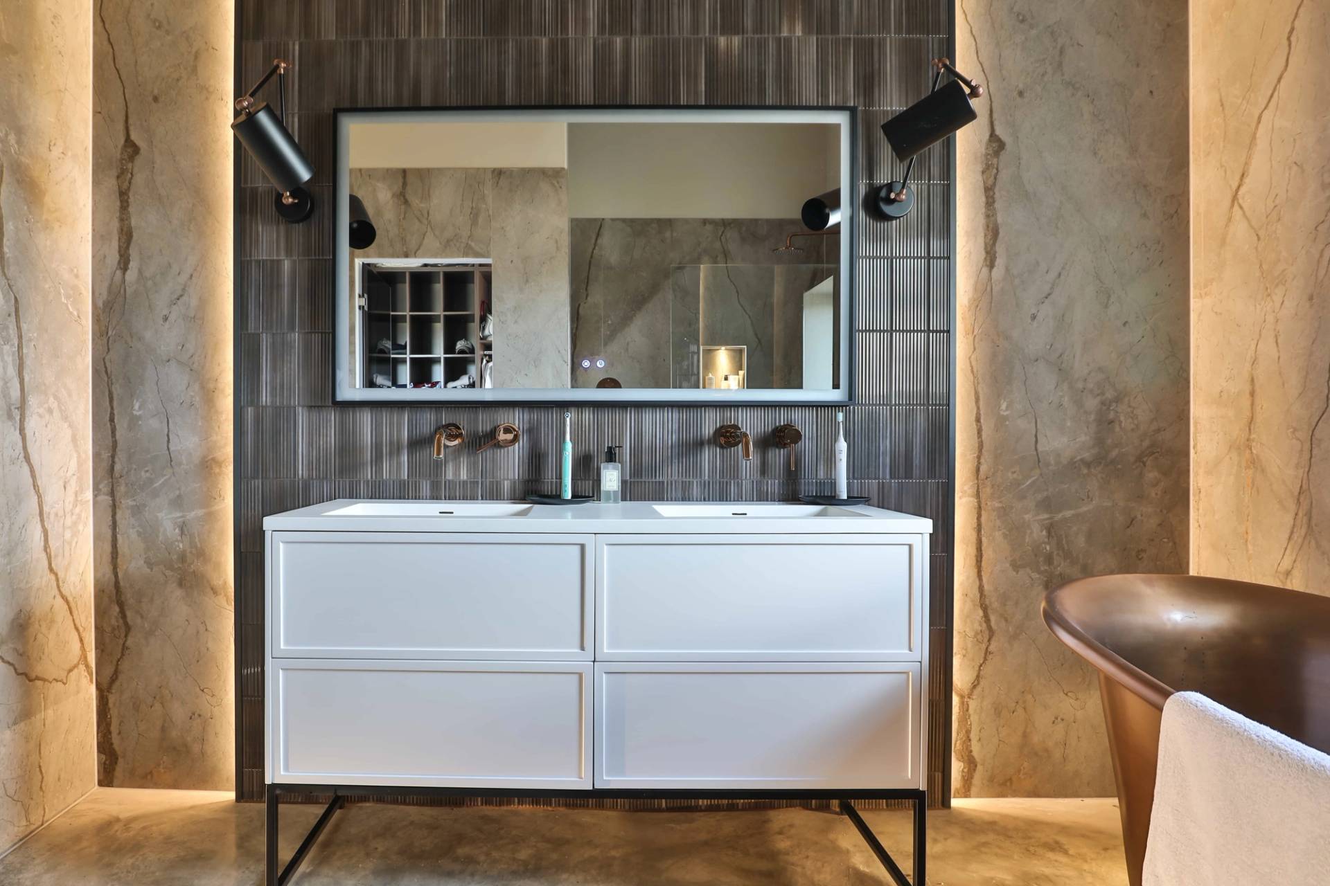 Sleek double sink vanity unit with white drawers, wall-mounted mirrors, and dark marble tiles, Love Locations CV23.
