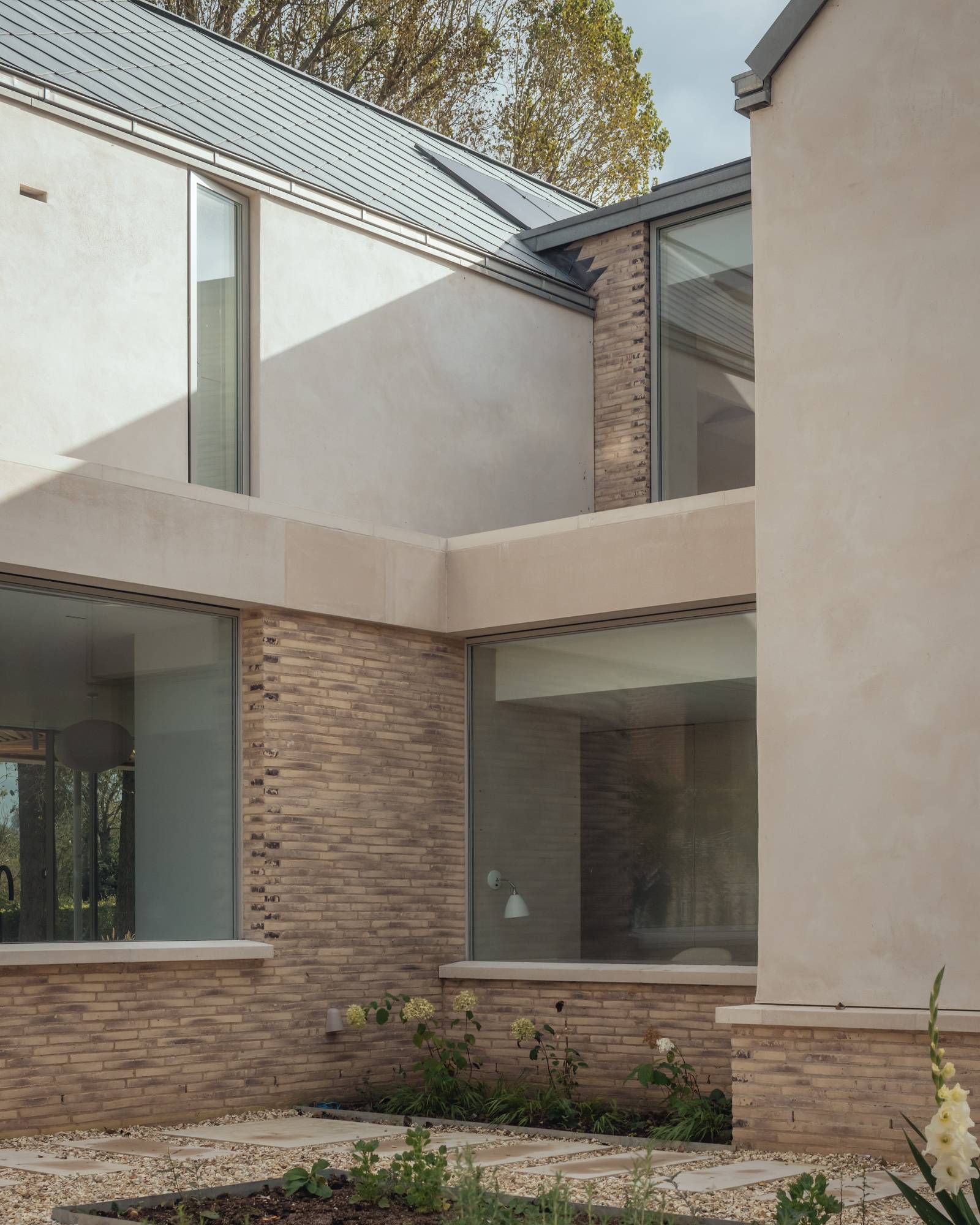 Architectural courtyard view highlighting L-shaped modern buildings, glass links, and soft exterior brickwork, ideal for architectural magazines, Love Locations SO20.