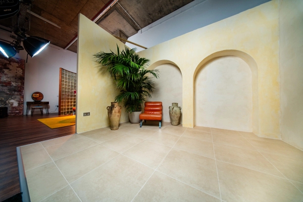 Wide-angle view of a large Mediterranean plaster arch set inside a creative photography studio space in Tottenham, Love Locations N15.