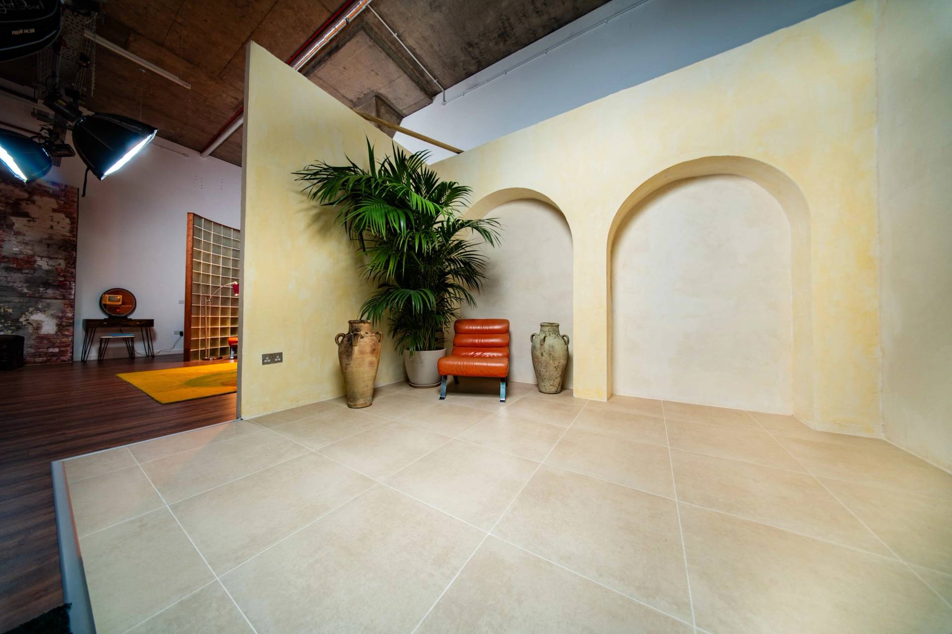 Wide-angle view of a large Mediterranean plaster arch set inside a creative photography studio space in Tottenham, Love Locations N15.