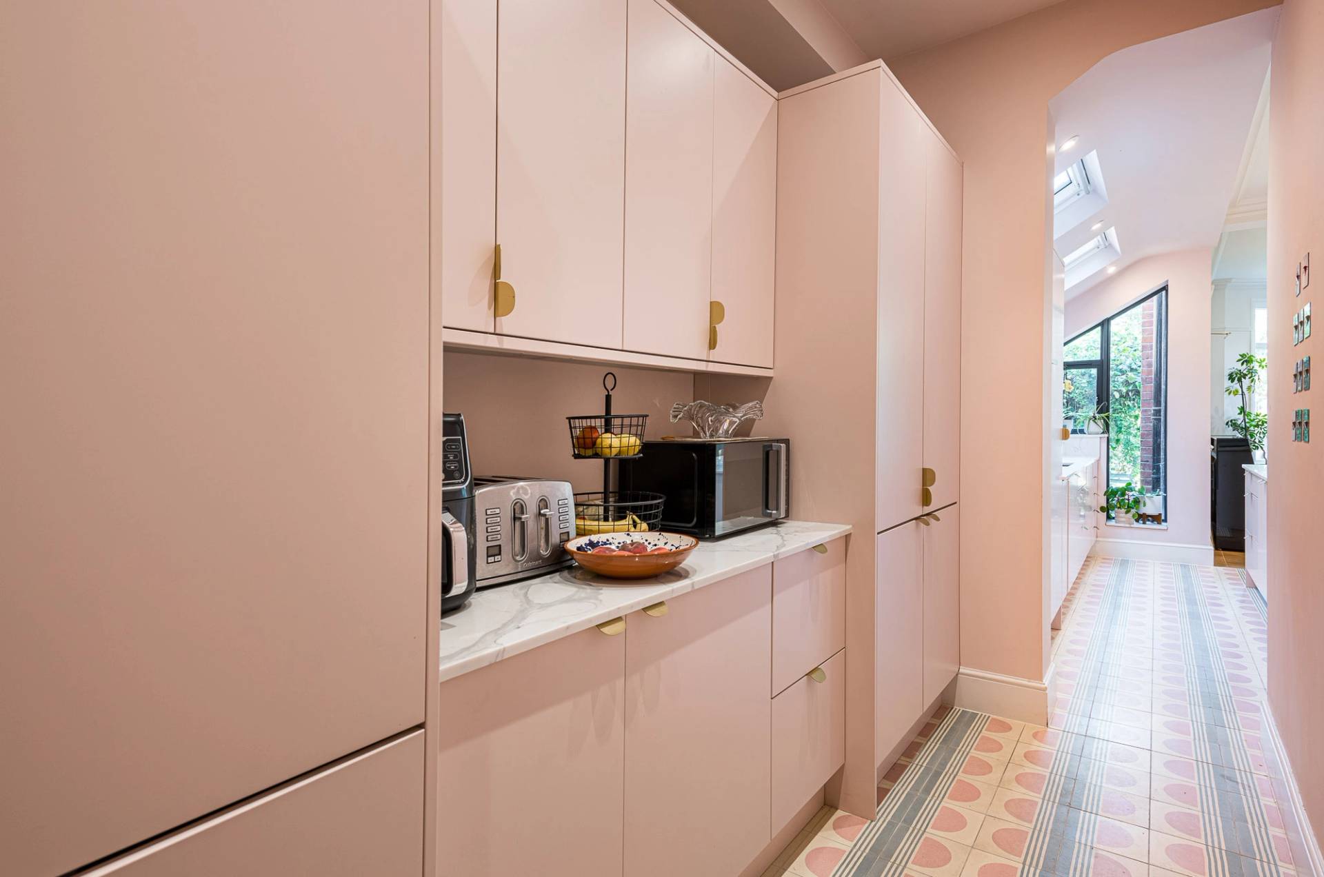 Bespoke floor-to-ceiling pink kitchen pantry cupboard storage units for lifestyle brand filming, Love Locations North London.